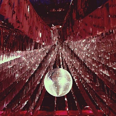 Disco ball hanging among silver fringe curtains