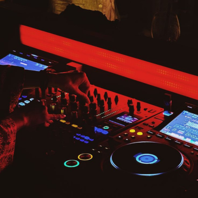 DJ decks glowing under red party lights